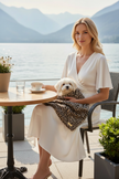 Donna in bianco al caffè con copertina leopardata e maltese